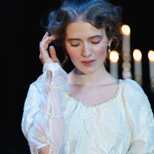 Portrait of a woman in a vintage dress and elegant hairstyle, evoking classical theater vibes.