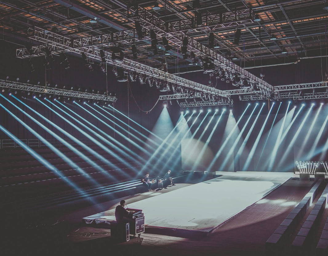 An expansive indoor stage with dramatic lighting setup, ready for a performance or event.